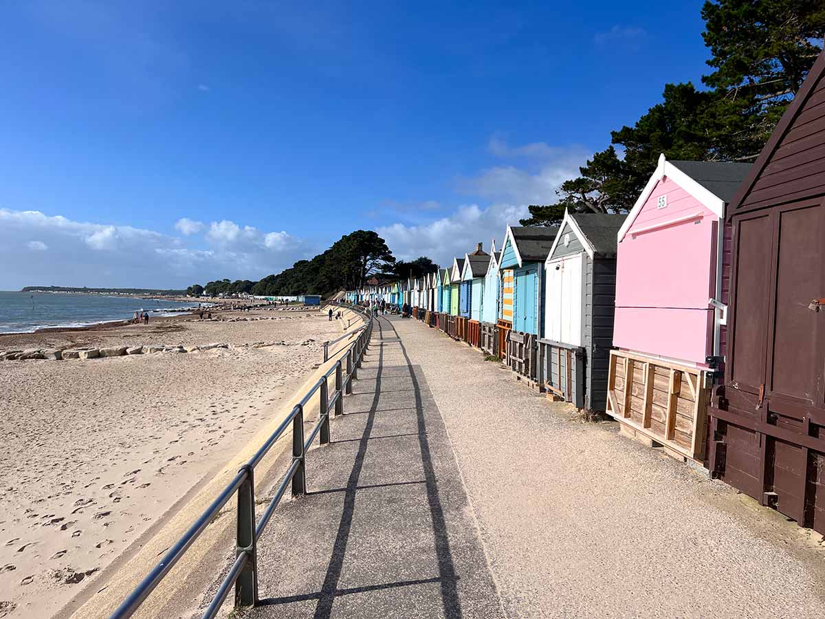 Colourful beach huts line the back of the promenade at Friars Cliff